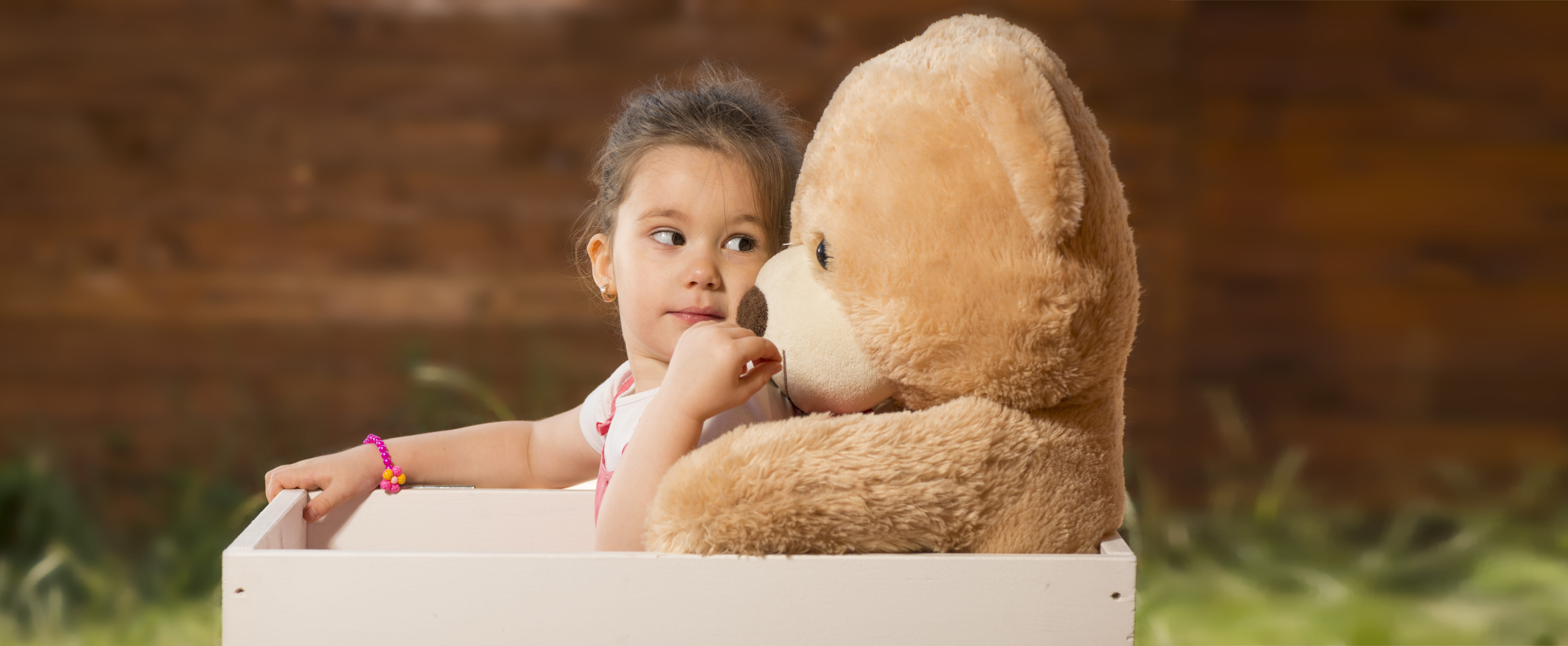 a little girl holding a teddy bear
